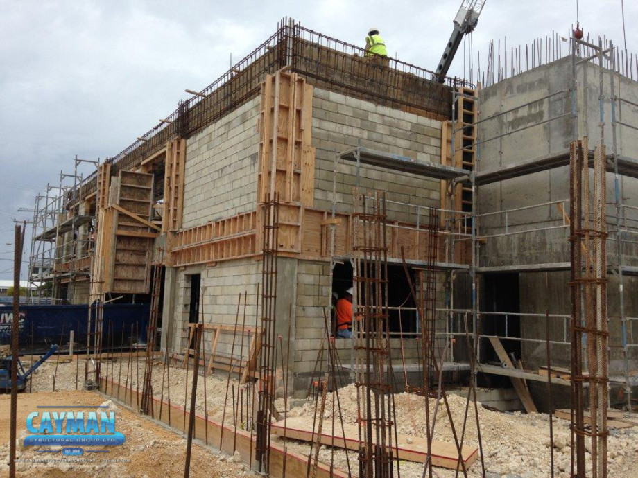Workers can be seen inside of the new Cayman First building as shell construction continues.