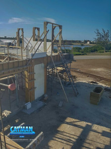 A wooden ladder leads up to the second story as construction continues on this custom luxury home in the Cayman Islands.