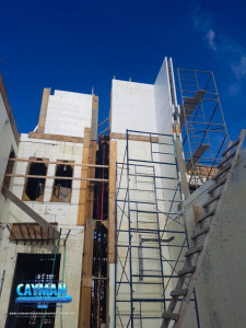 A side view of the house shows the walls are being finished off in certain areas.